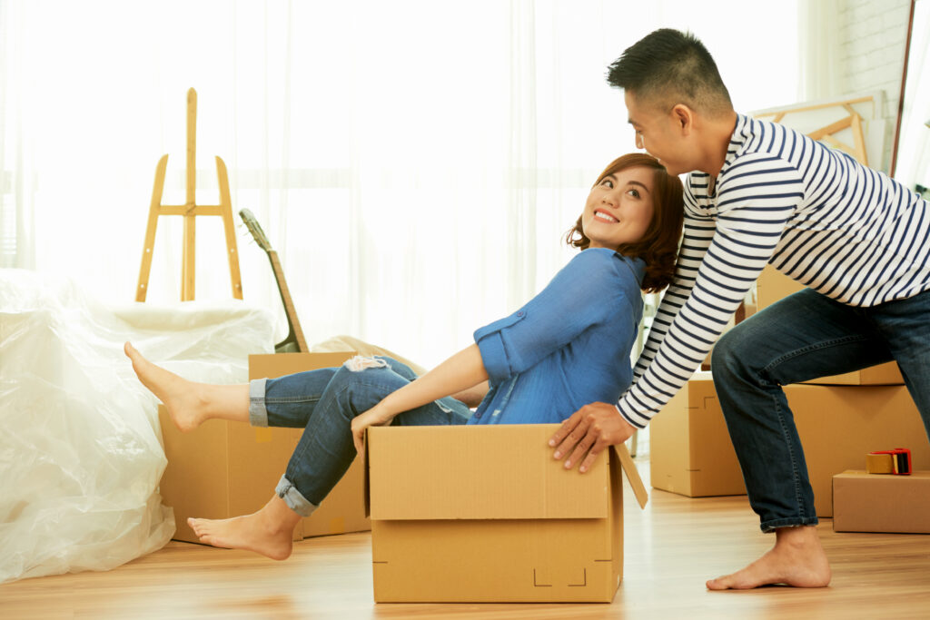 Happy asian couple packing boxes and preparing for a stress-free move-out.